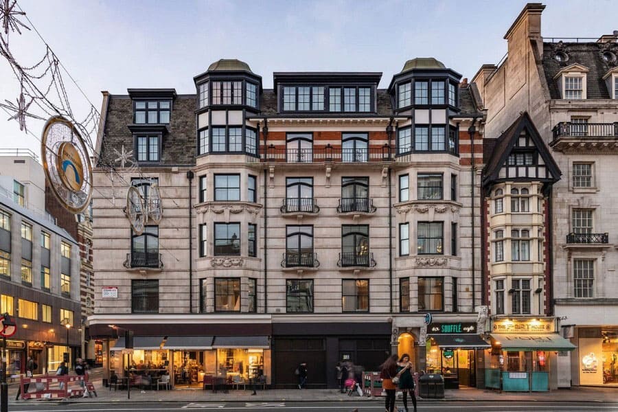 A cozy hotel room with a mini-kitchen and a window seat overlooking Covent Garden.