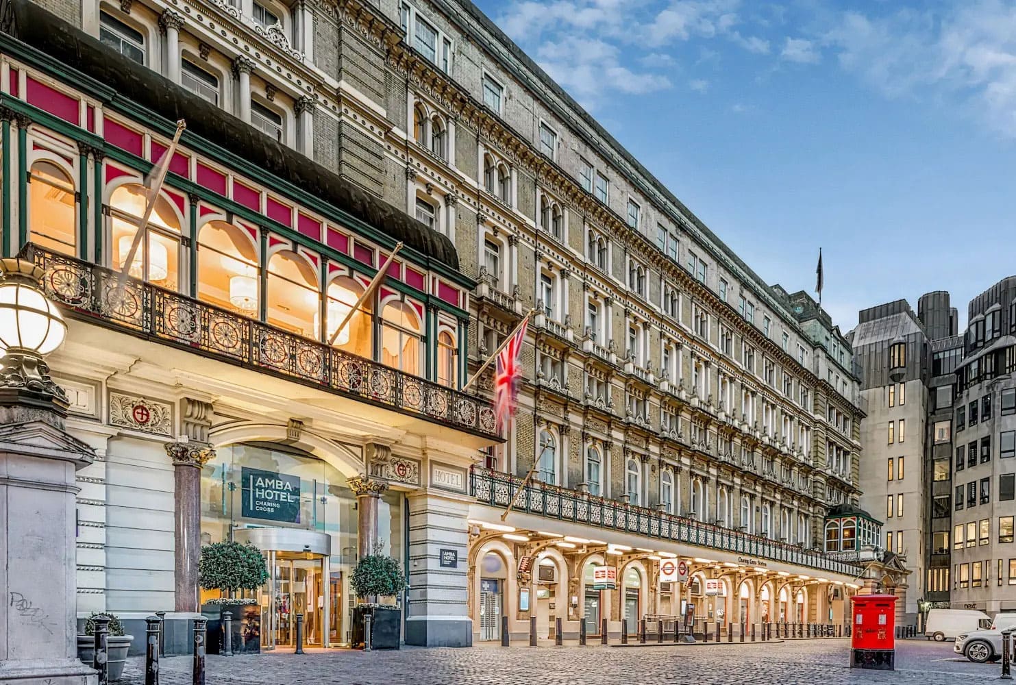 A grand Victorian hotel facade with Union Jack flags flying.