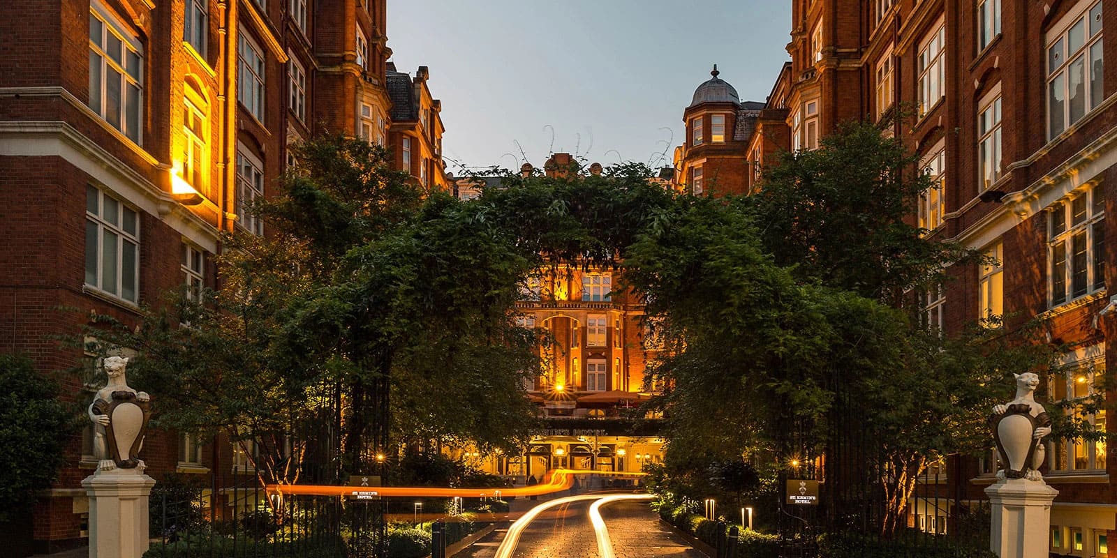 A hotel exterior with a grand staircase leading to the entrance, decorated with flower boxes.