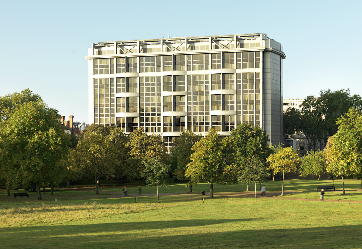 A modern hotel room with a view of Kensington Gardens, featuring a king-sized bed and a child's teepee.